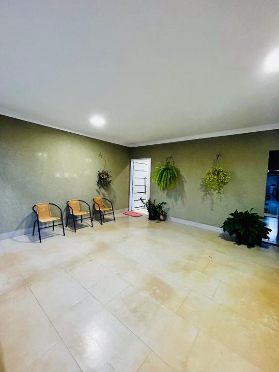 an empty room with chairs and plants on the wall at Casa Rio verde para Tecnoshow in Rio Verde