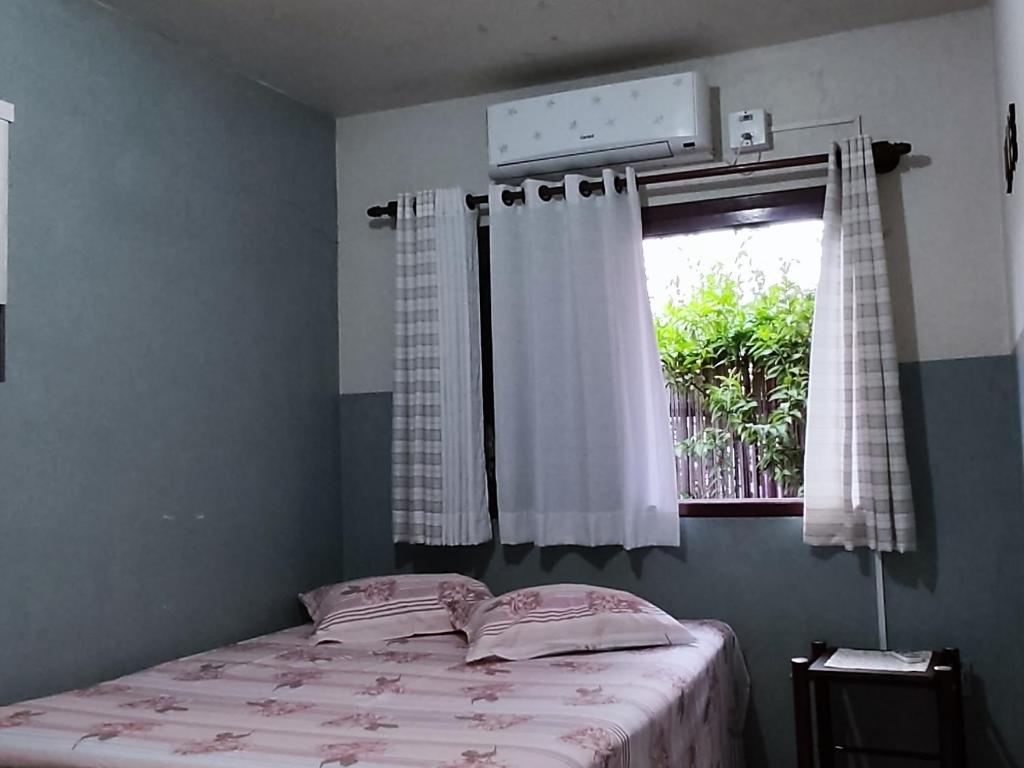 Habitación pequeña con cama y ventana en uma casa na viagem, en Três Cachoeiras