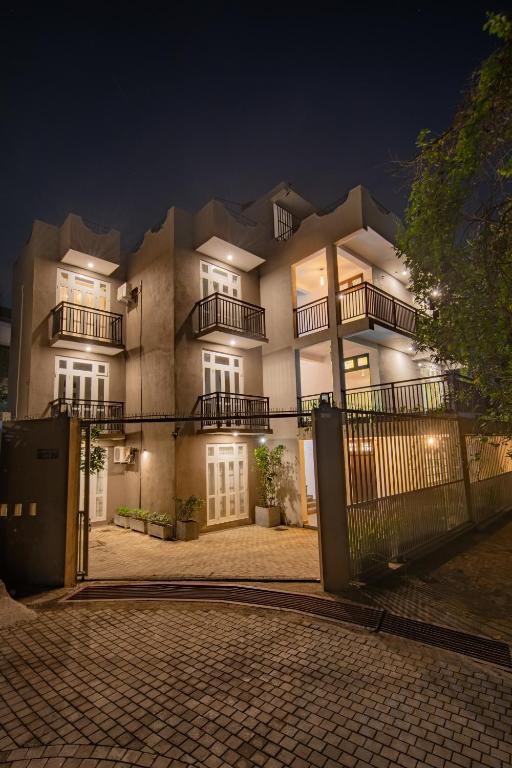 a large building with a fence in front of it at Glowing Crescent Holiday Apartments in Rajagiriya