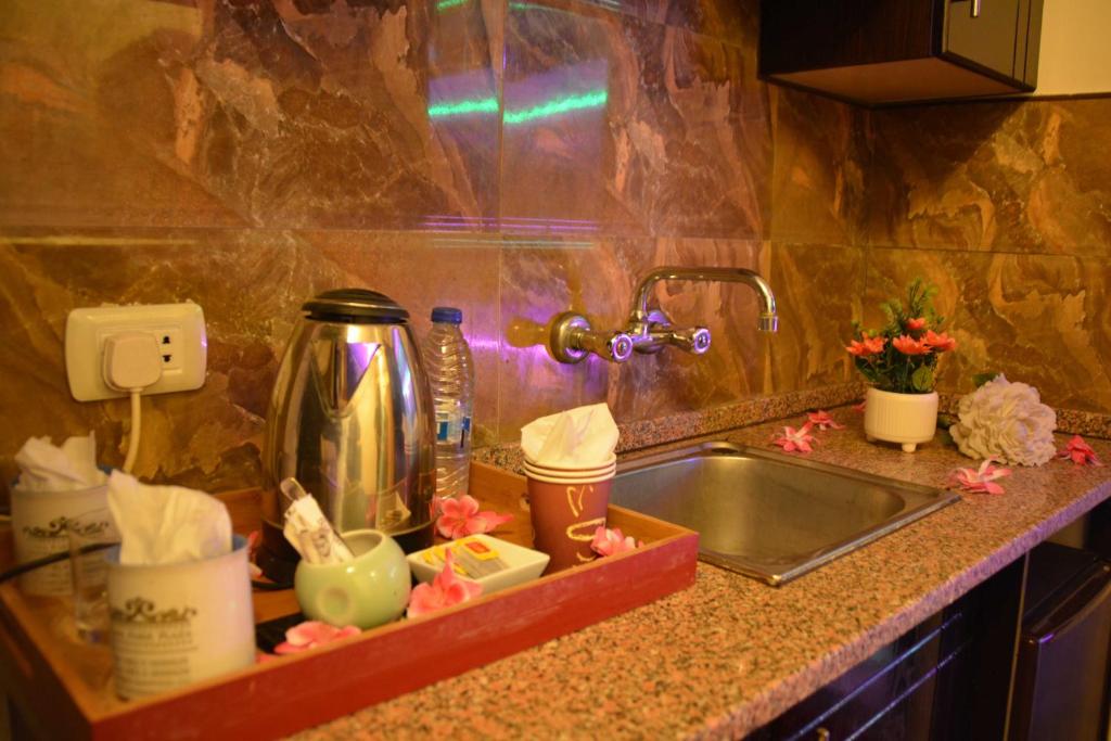 a kitchen counter with a sink next to a sink at Sama Paris Plaza Hotel in Amman