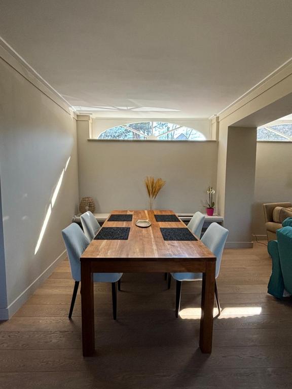 a dining room with a wooden table and chairs at Duplex Rosières - 12’ de Bruxelles in Rixensart