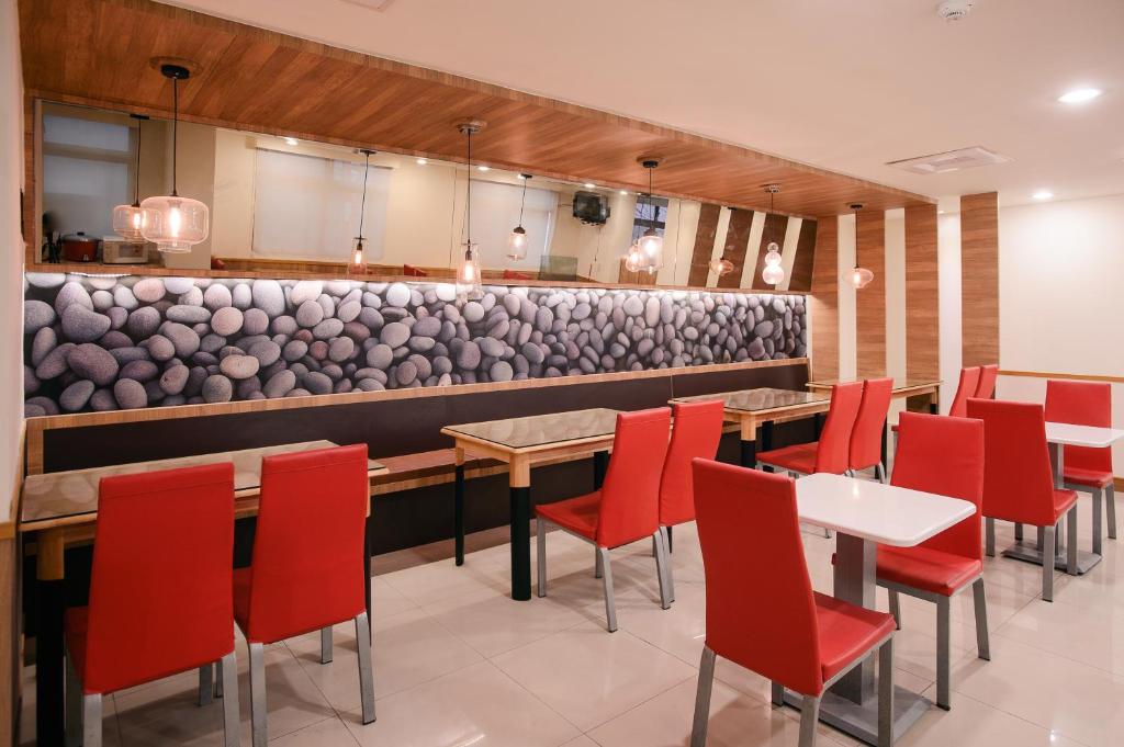 a restaurant with red chairs and tables and a bar at KIWI-Taichung Station Branch 1 in Taichung