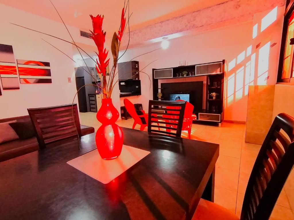 un jarrón rojo sobre una mesa en la sala de estar en Tucacas, Sotavento, en Boca de Aroa
