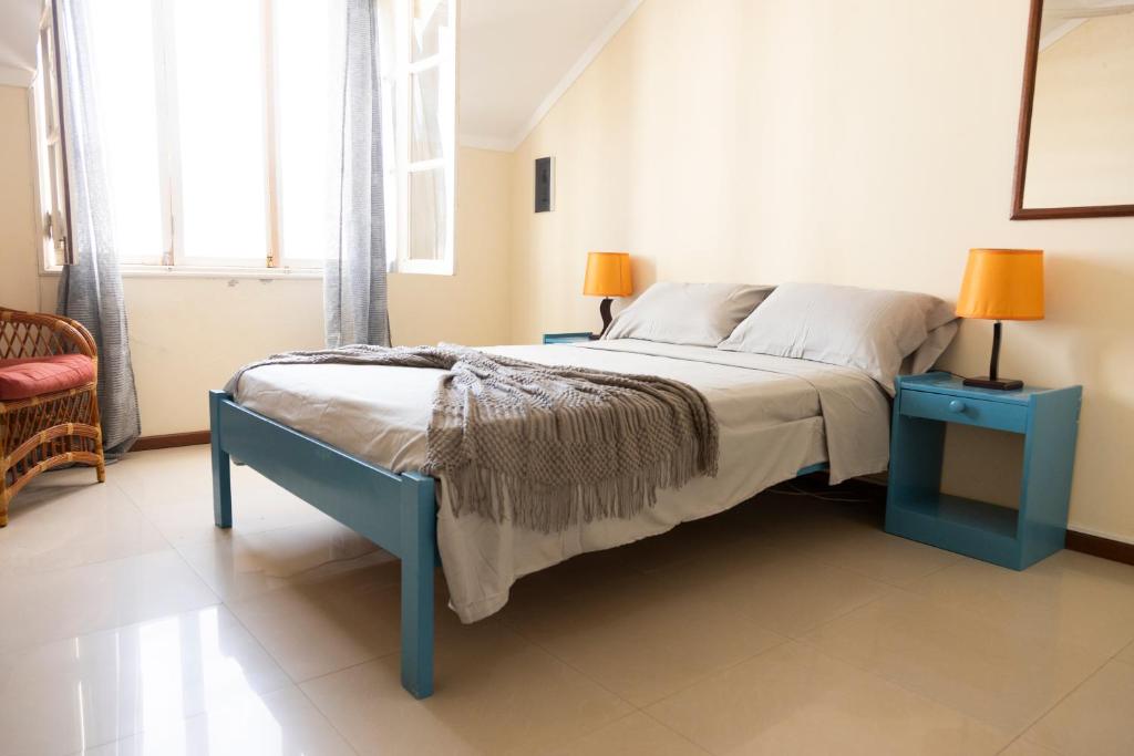 ein Schlafzimmer mit einem Bett mit einem blauen Endtisch in der Unterkunft Cozy studio apt in Terra Branca with WIFI - LCGR in Praia