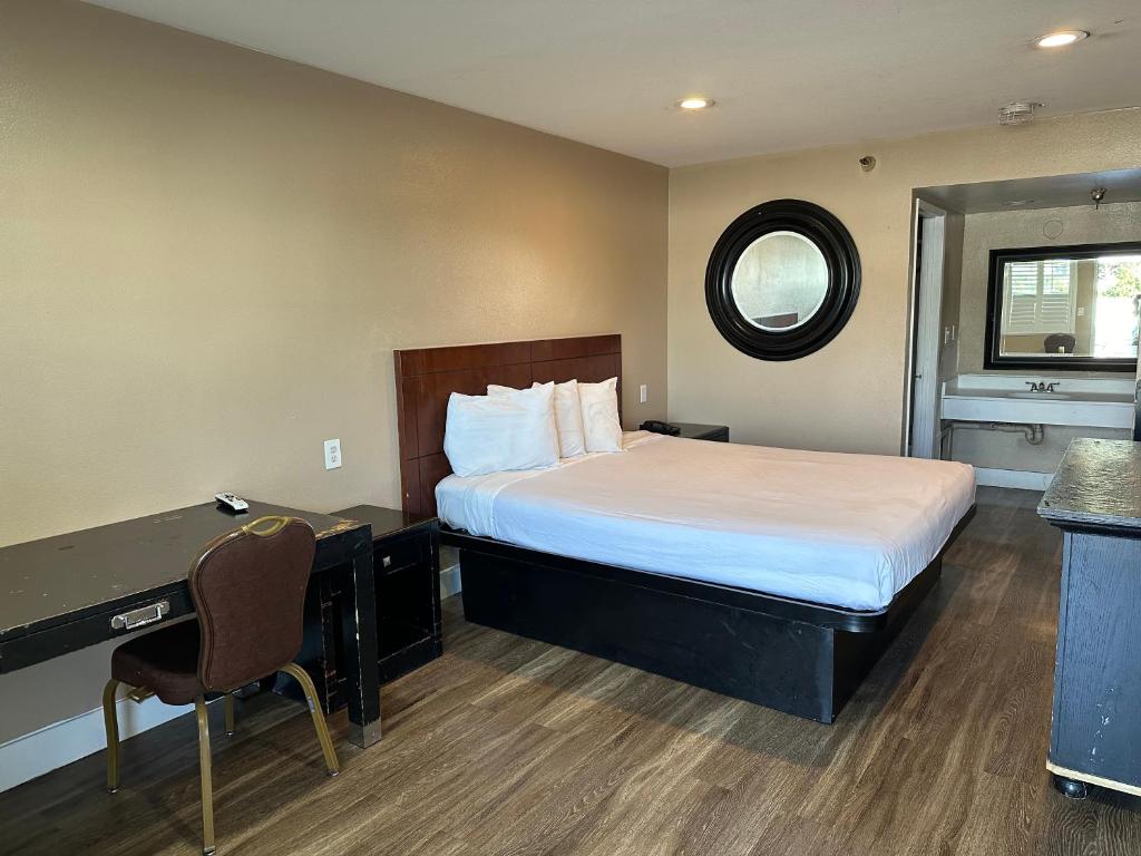 um quarto de hotel com uma cama e uma secretária em The Dixie Orange County em Stanton