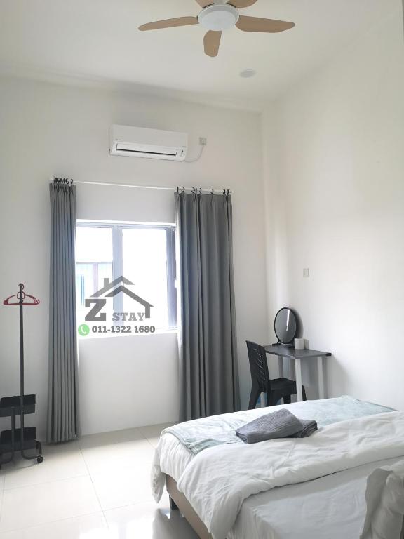 ein weißes Schlafzimmer mit einem Bett und einem Fenster in der Unterkunft Zstay homestay in Teluk Intan