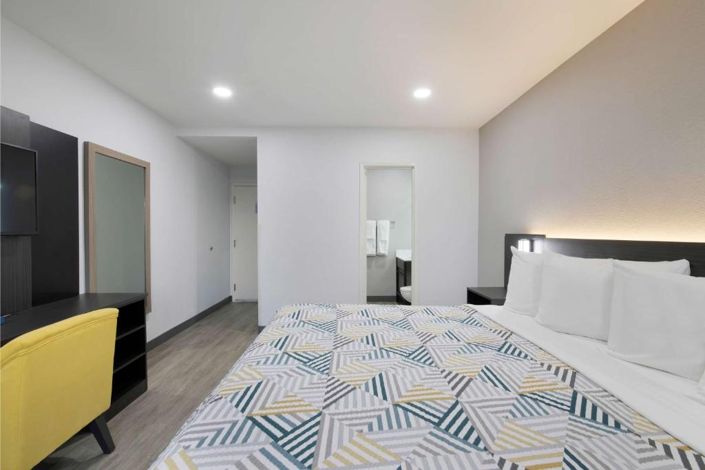 a bedroom with a large bed and a yellow chair at Motel 6-Atlanta, GA - Downtown in Atlanta