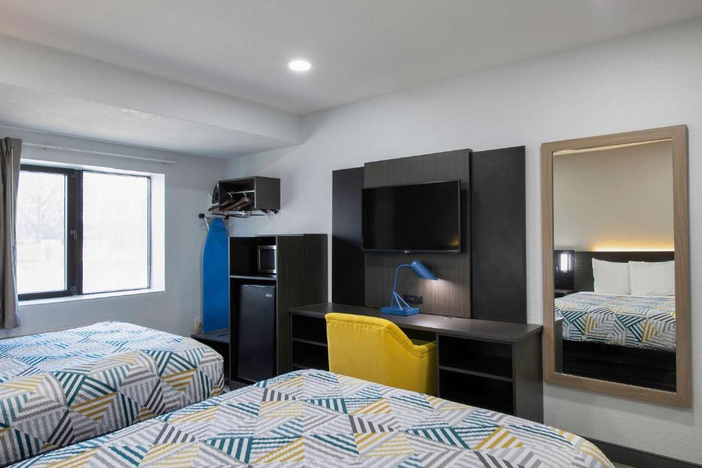a hotel room with two beds and a desk and a mirror at Motel 6-Atlanta, GA - Downtown in Atlanta