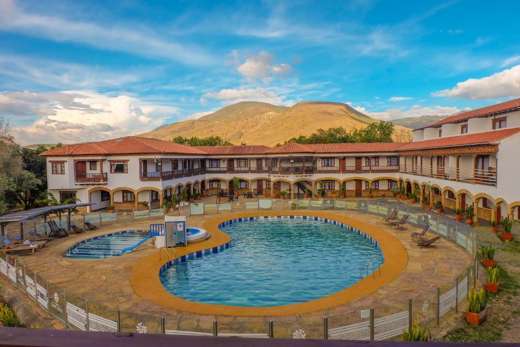 un complejo con piscina y montañas de fondo en Hotel Gran Sirius, en Sáchica