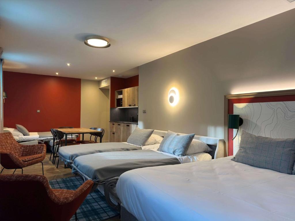 a hotel room with three beds and a table at Best Western Hotel Coeur de Maurienne in Saint-Jean-de-Maurienne