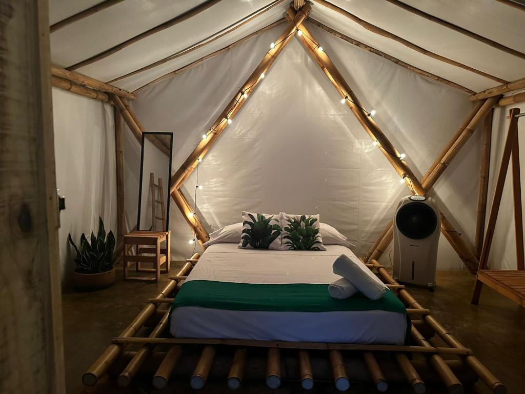 Montepio的住宿－Glamping Las Olas by Rotamundos，帐篷内一间卧室,配有一张床
