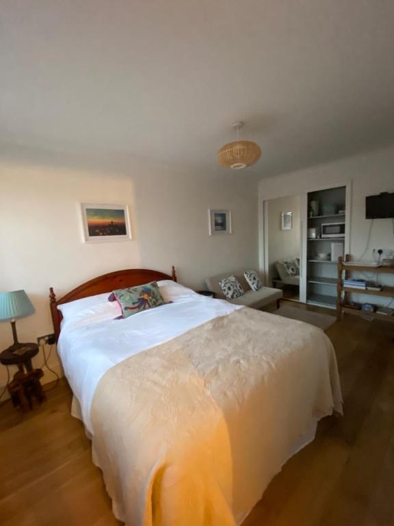 a bedroom with a large bed and a living room at Bright Suite in Whitstable