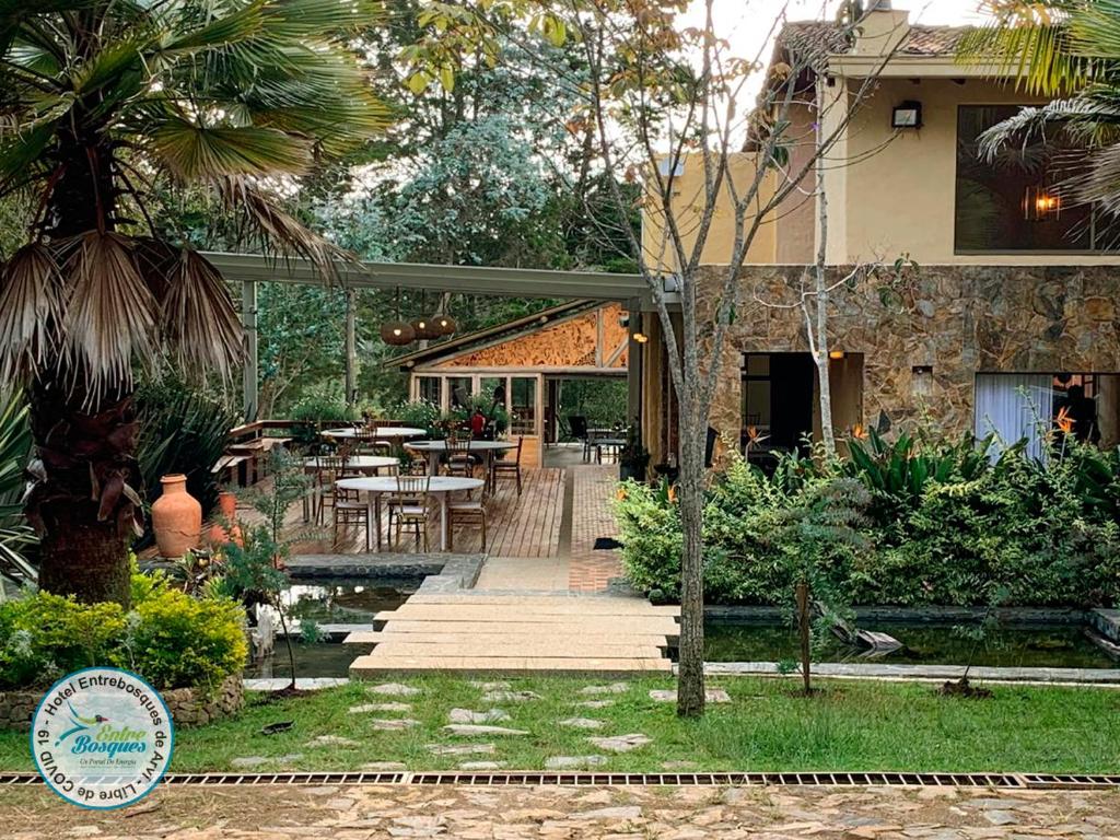 a house with a patio with a table and chairs at Entrebosques in Santa Elena