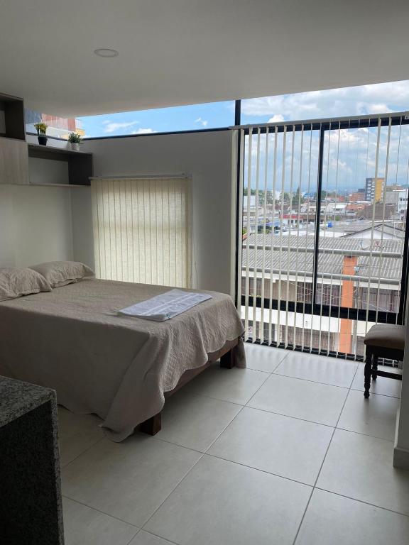 a bedroom with a bed and a large window at Excelente nuevo Apartaestudio in Popayan