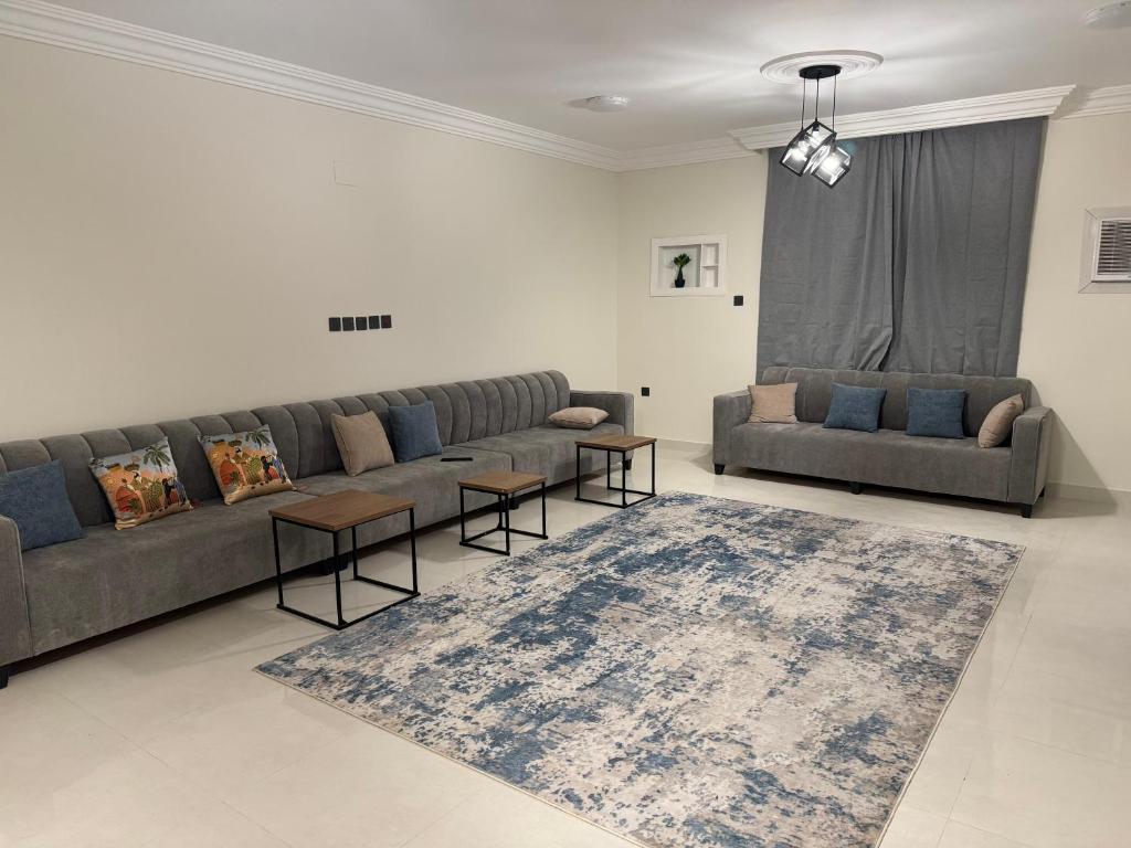 Almansour Laxury Apartement في المدينة المنورة: غرفة معيشة مع أريكة وسجادة
