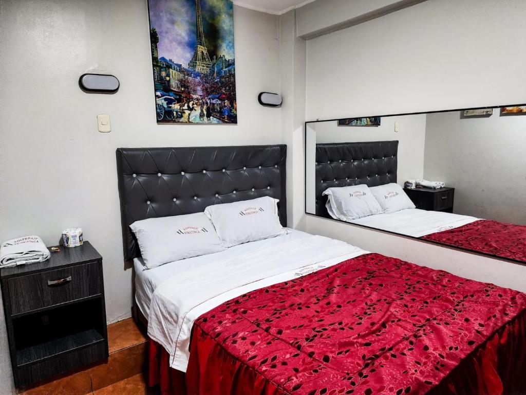 1 Schlafzimmer mit 2 Betten und einer roten Decke in der Unterkunft Hostal Paris in Lima