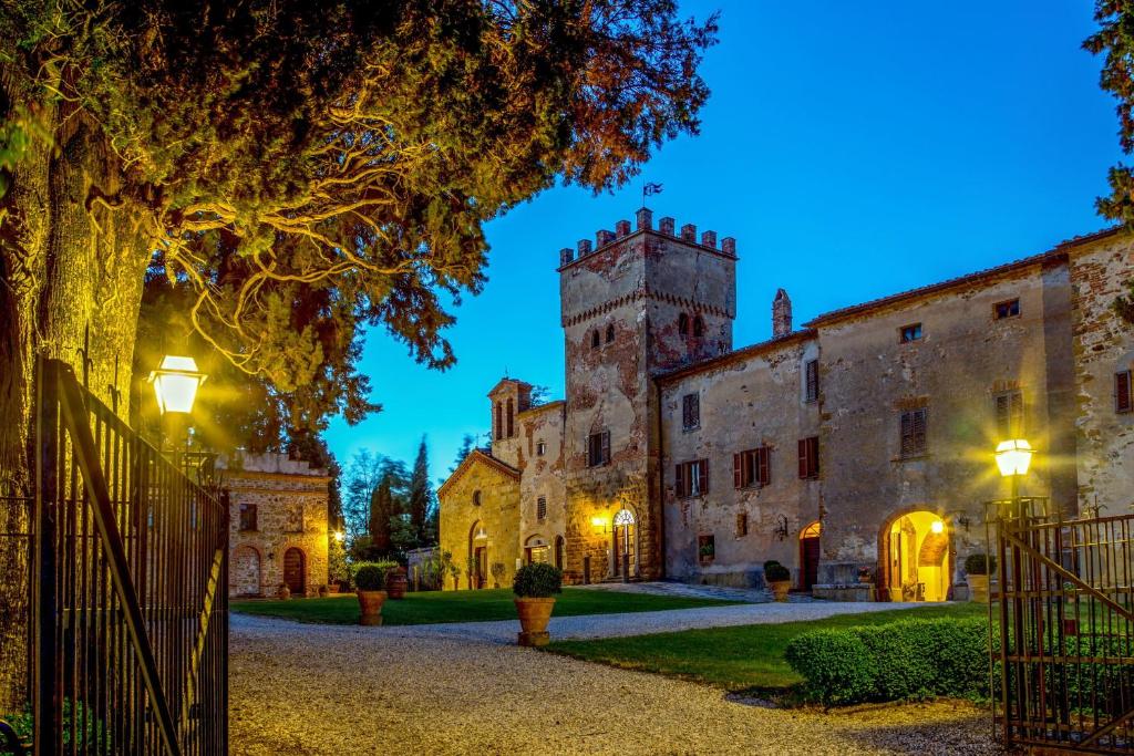 an estate at night with a gate and a castle at Abbadia Sicille Relais in Trequanda