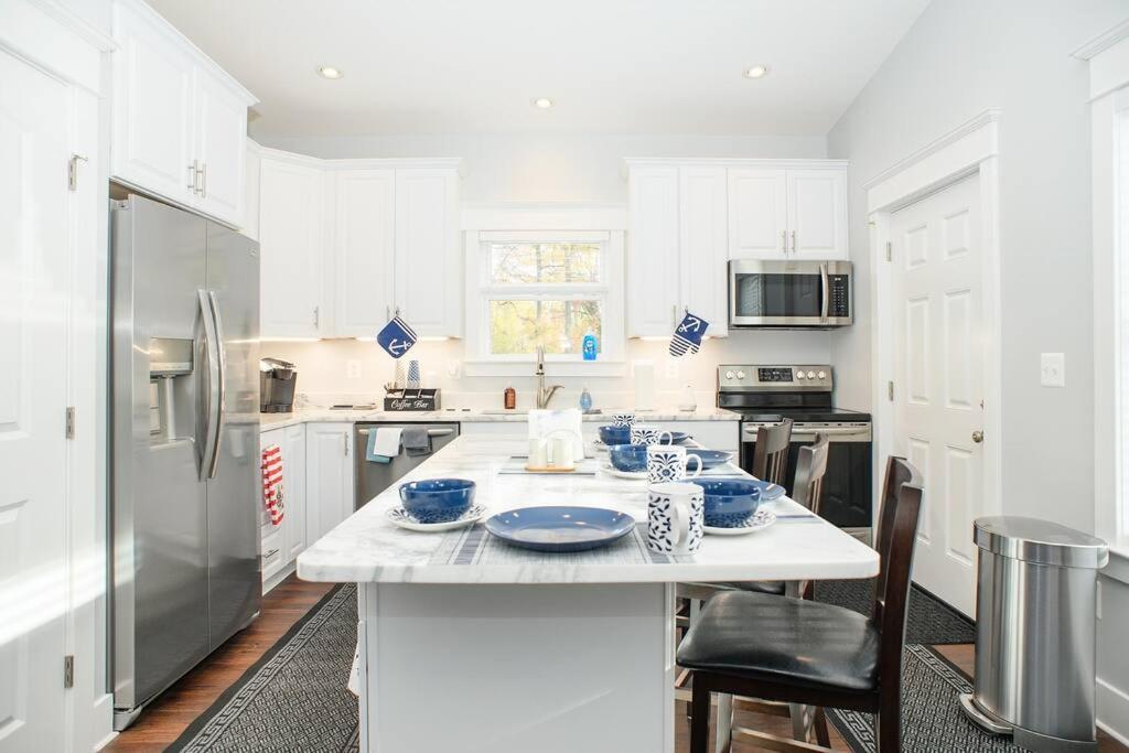 a white kitchen with a table with blue dishes on it at BayRidge house by Quiet Waters, Thomas Point Parks in Annapolis