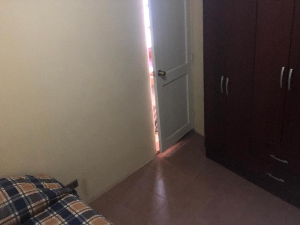 Cette chambre dispose d'une porte, d'un lit et d'un placard. dans l'établissement Habitación en Concon y área compartida, à Concón