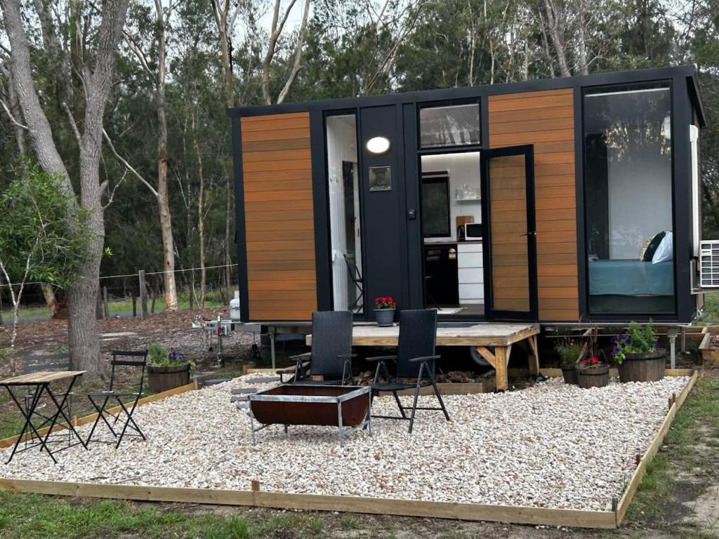 a tiny house with a table and chairs at Tiny Retreat Noosa in Cooroibah