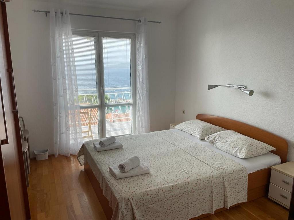 ein Schlafzimmer mit einem Bett und einem großen Fenster in der Unterkunft Apartments with a parking space Zivogosce - Blato, Makarska - 22253 in Podgora