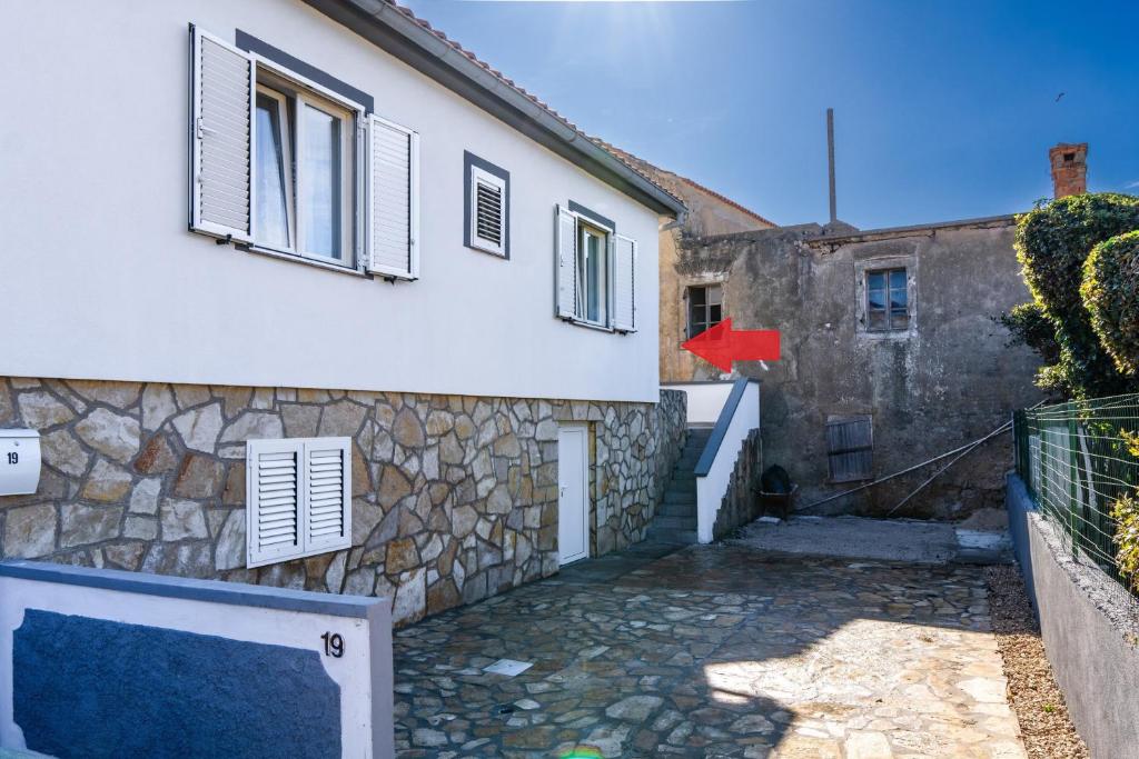 una casa blanca con un muro de piedra en Apartments with parking space Vir - 22682, en Vir