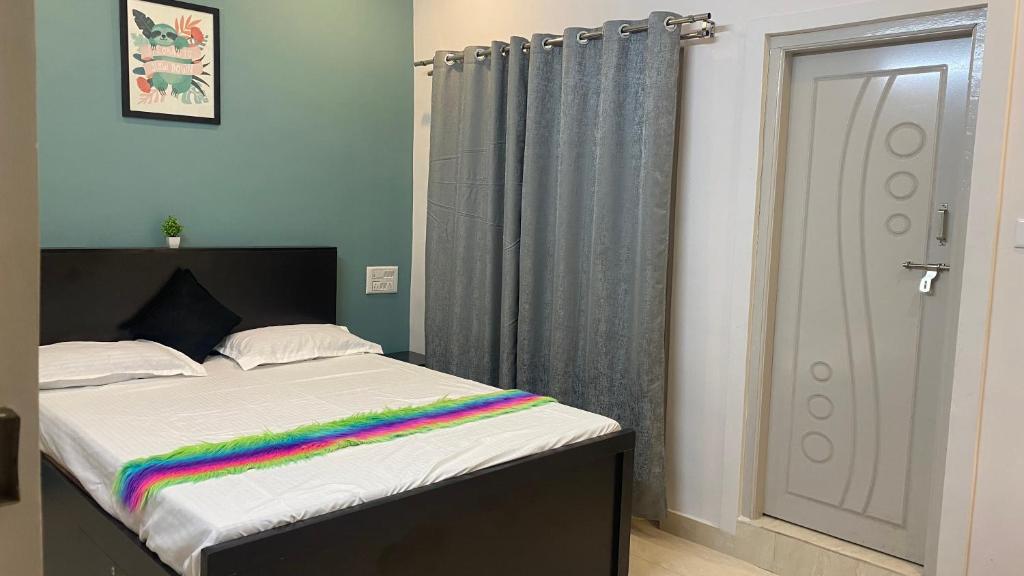 Un dormitorio con una cama con una manta de arco iris. en Rabbit Hill Farm, en Bangalore