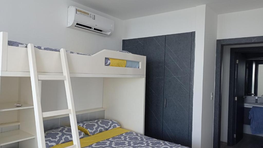 a bedroom with a bunk bed with a ladder at Grand Diamond Beach Tonsupa in Tonsupa