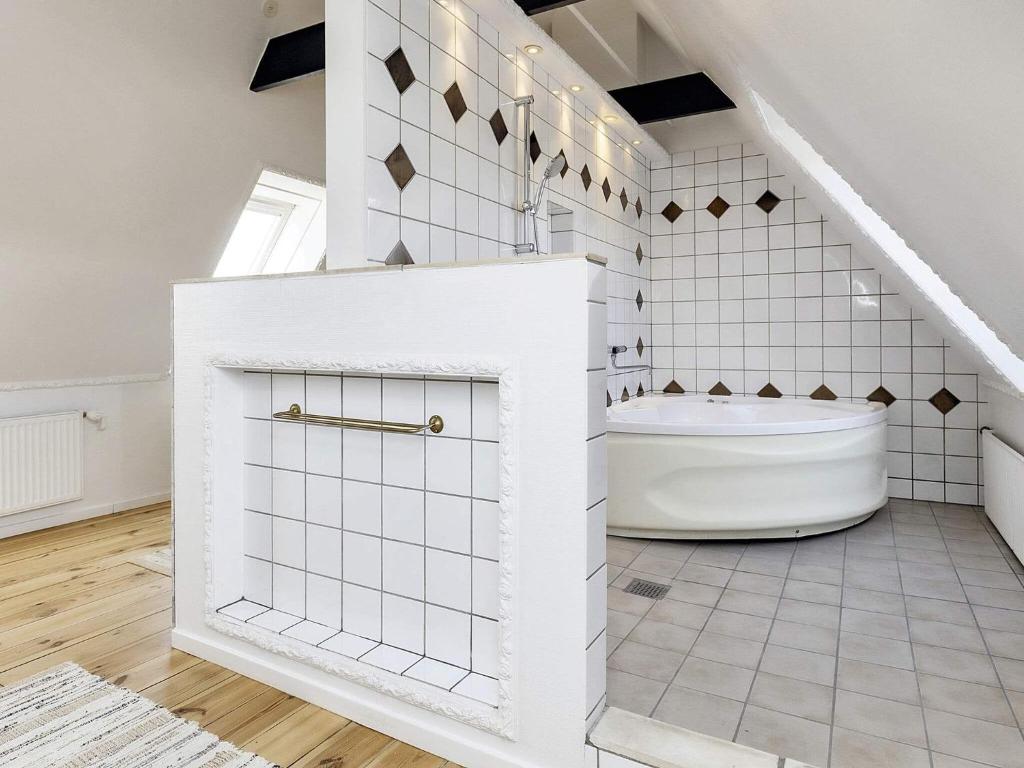 a white bathroom with a tub and a staircase at 20 person holiday home in Svendborg in Svendborg