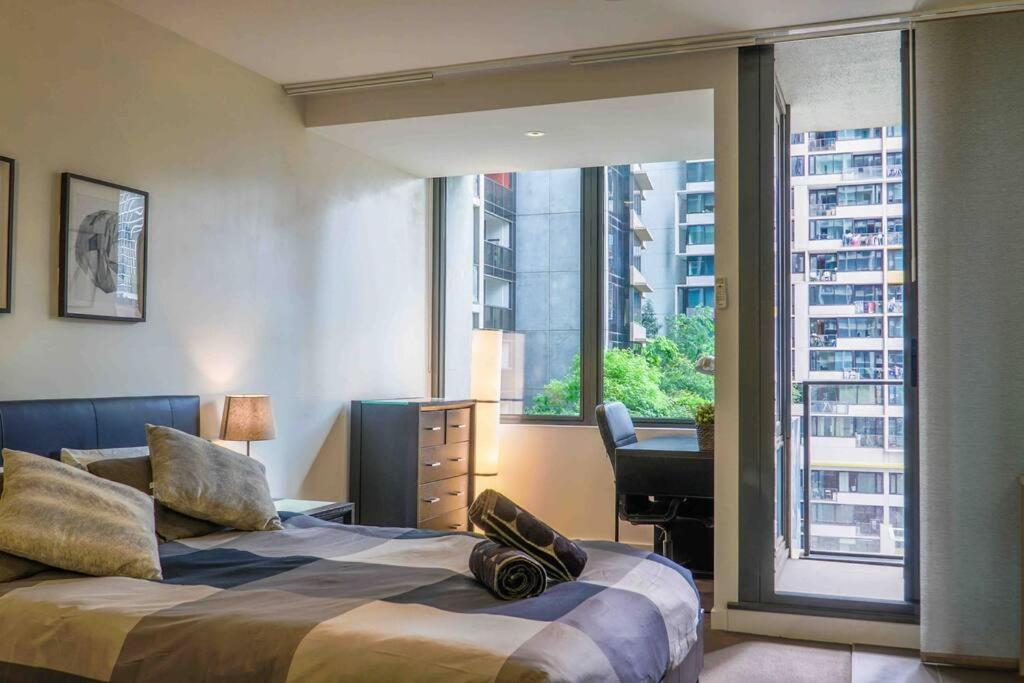 a bedroom with a bed and a desk and a window at Best location in the CBD; pool, gym, rockclimbing +7 other amenities in Melbourne