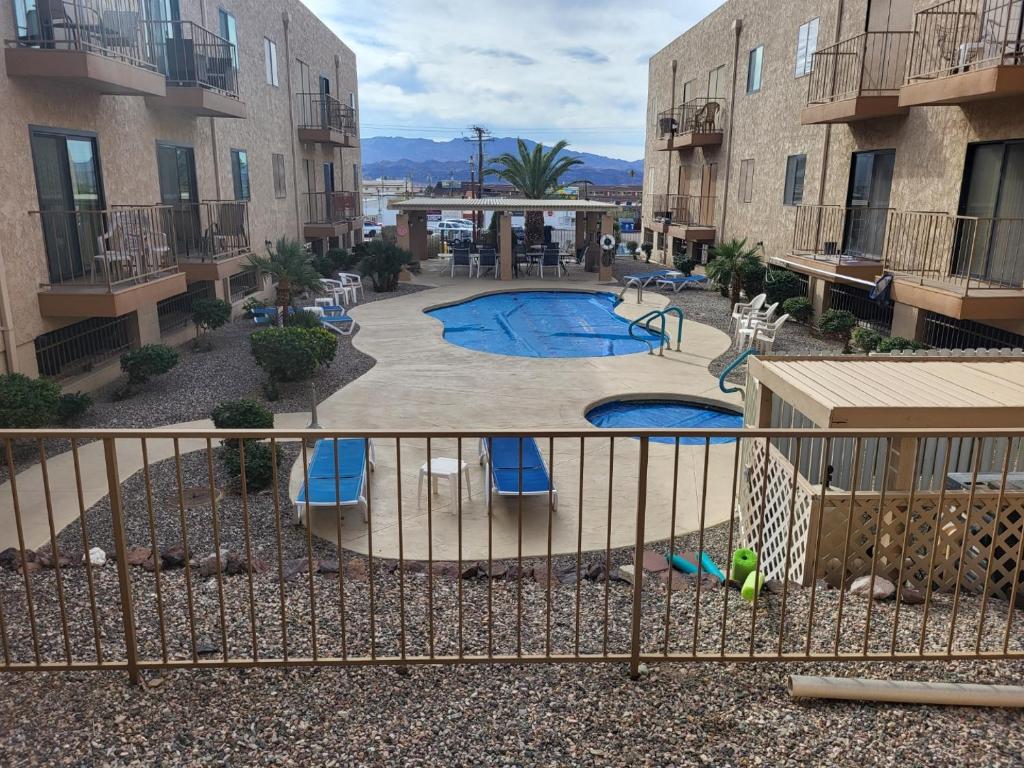an apartment complex with a swimming pool in a courtyard at 1st Floor Condo in the Desert w/ Pool, Spa & BBQ in Lake Havasu City