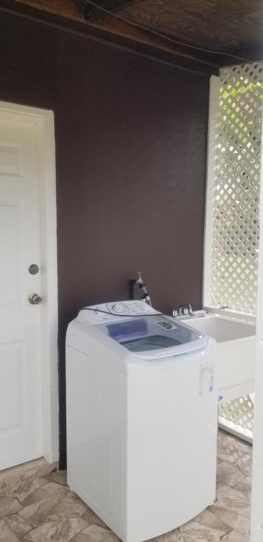 a washing machine in a room with a sink at Ali's Apartment in Hyde Park