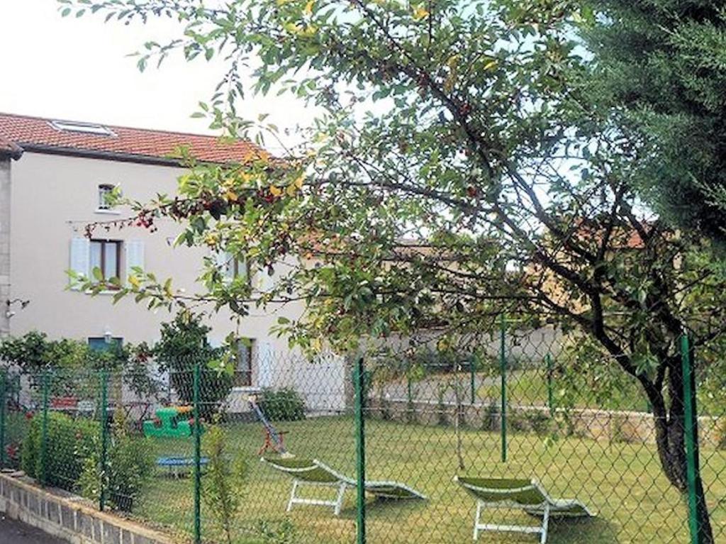 einen Zaun mit Kettenbindung mit zwei Schaukeln in einem Hof in der Unterkunft Gîte Vacances en Auvergne in Saint-Géron