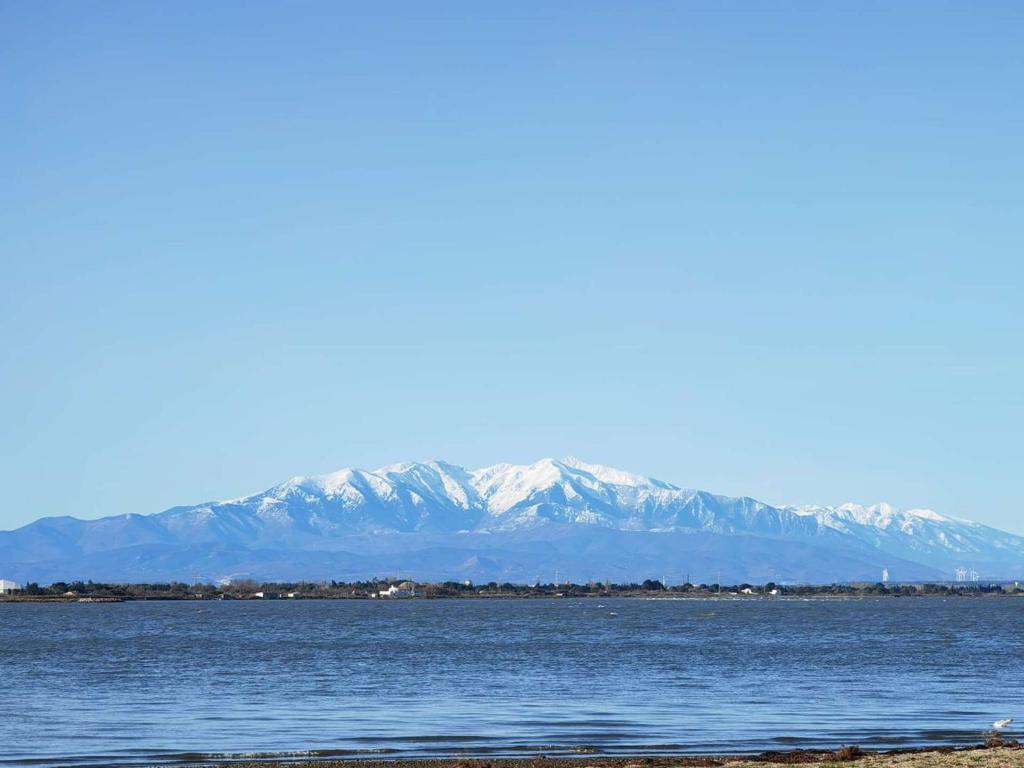 une grande étendue d'eau avec des montagnes en arrière-plan dans l'établissement T2 climatisé avec internet et piscine, 4 couchages - Le Barcarès - FR-1-195-107, au Barcarès