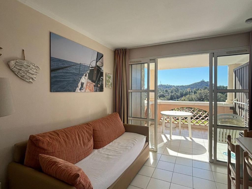 d'un salon avec un canapé et un balcon. dans l'établissement 2 pièces pour 4 avec piscine, parking et climatisation - FR-1-504-682, à Saint-Raphaël