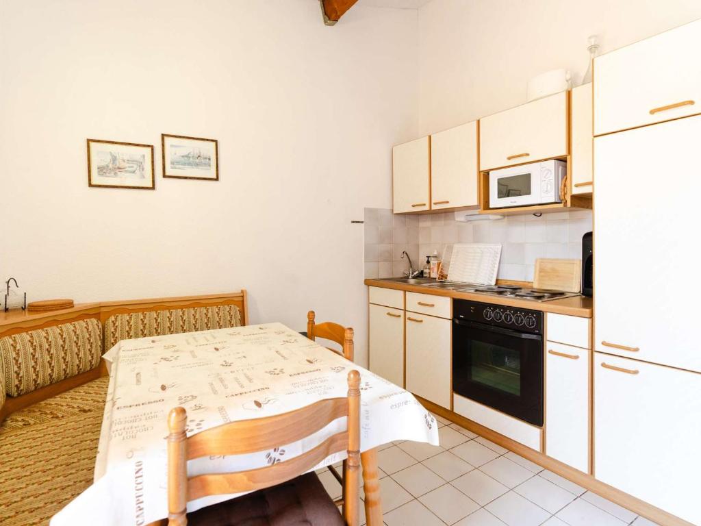 uma pequena cozinha com uma mesa e um micro-ondas em Villa Narbonne, 3 pièces, 6 personnes - FR-1-409-257 em Narbona