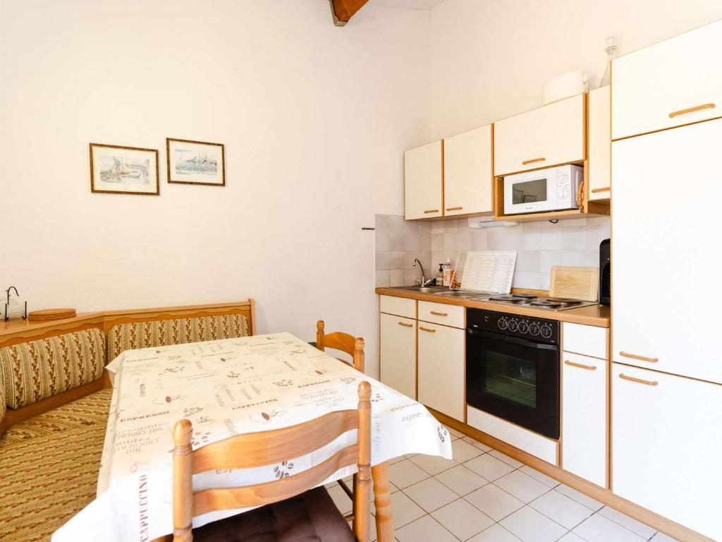une petite cuisine avec une table et un micro-ondes dans l'établissement Pavillon pour 6, proche plage, avec terrasse, parking et animaux acceptés - FR-1-409-257, à Narbonne