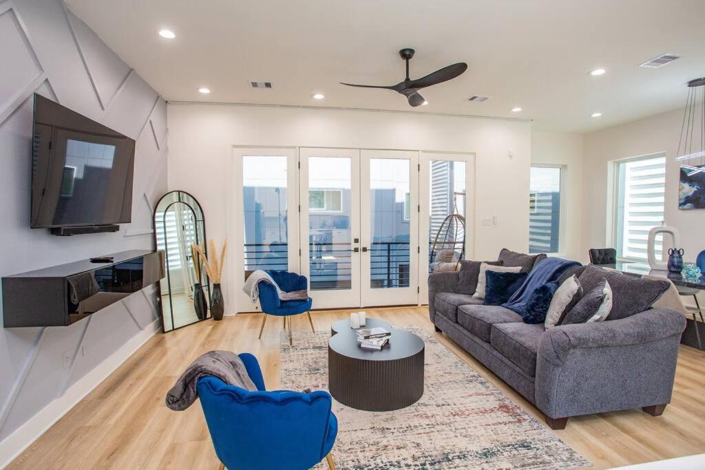 a living room with a couch and a tv at Stylish 3 Story Townhouse near East Downtown in Houston