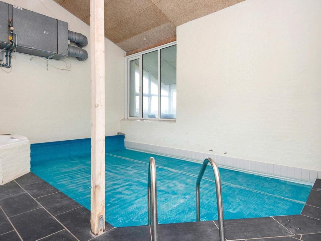 uma piscina com água azul num quarto em 10 person holiday home in Haderslev em Diernæs