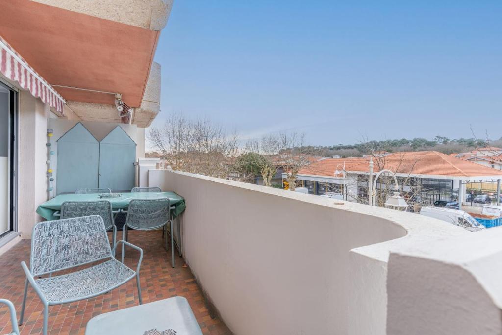 un patio avec une table et des chaises sur un balcon dans l'établissement Appartement des Tchanquées - Welkeys, à Arcachon