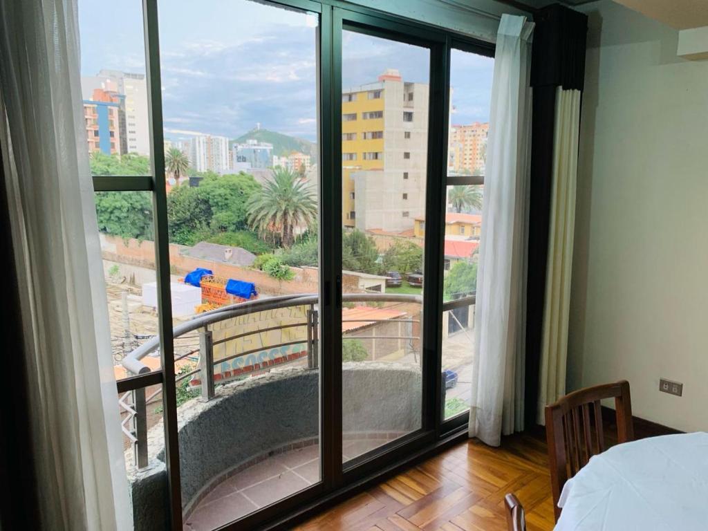 a bedroom with a large window with a view at Departamento cómodo Cala Cala in Cochabamba