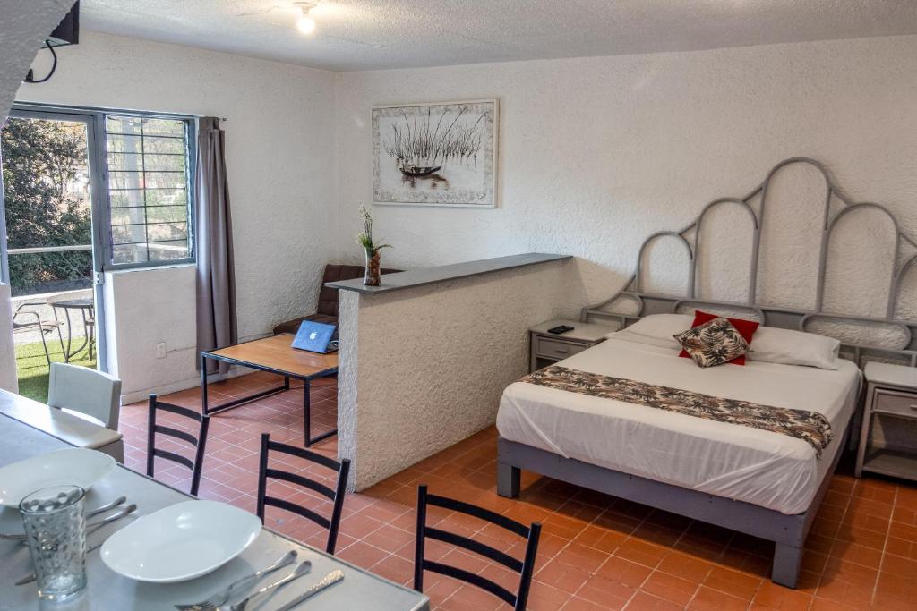 a bedroom with a bed and a table and chairs at Suite/ terraza en la glorieta chapalita in Guadalajara