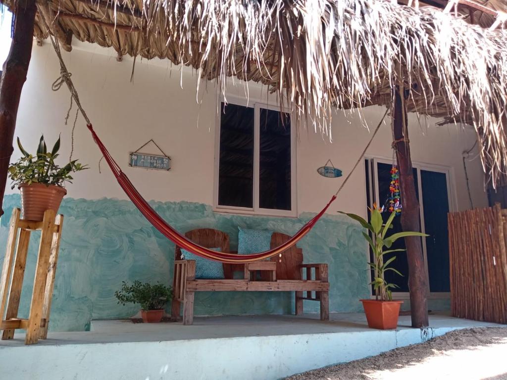 eine Veranda mit Hängematte und ein Haus in der Unterkunft El Puente in El Paredón Buena Vista