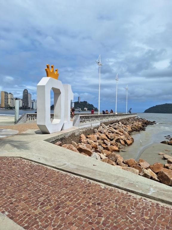 a large sign with a crown on it next to the water at Pé na areia Gonzaguinha São Vicente in São Vicente