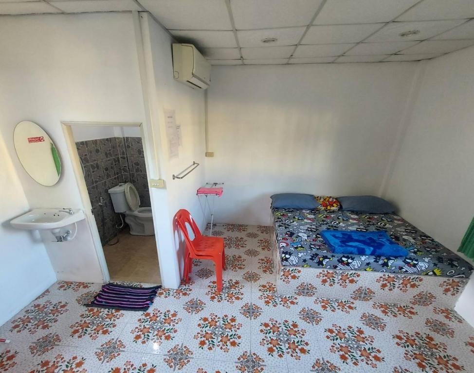 1 dormitorio con 1 cama y 1 silla roja en โรงแรมดาวทองรีสอร์ทมหาสารคาม, en Ban Nong Chik