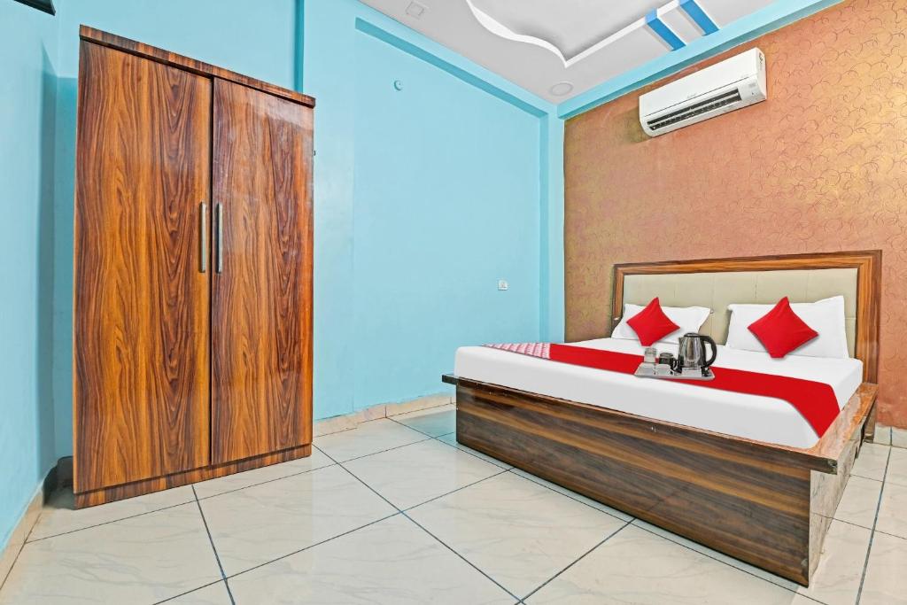 a bedroom with a bed and a wooden cabinet at OYO Flagship Hotel Shivnath in Kānpur