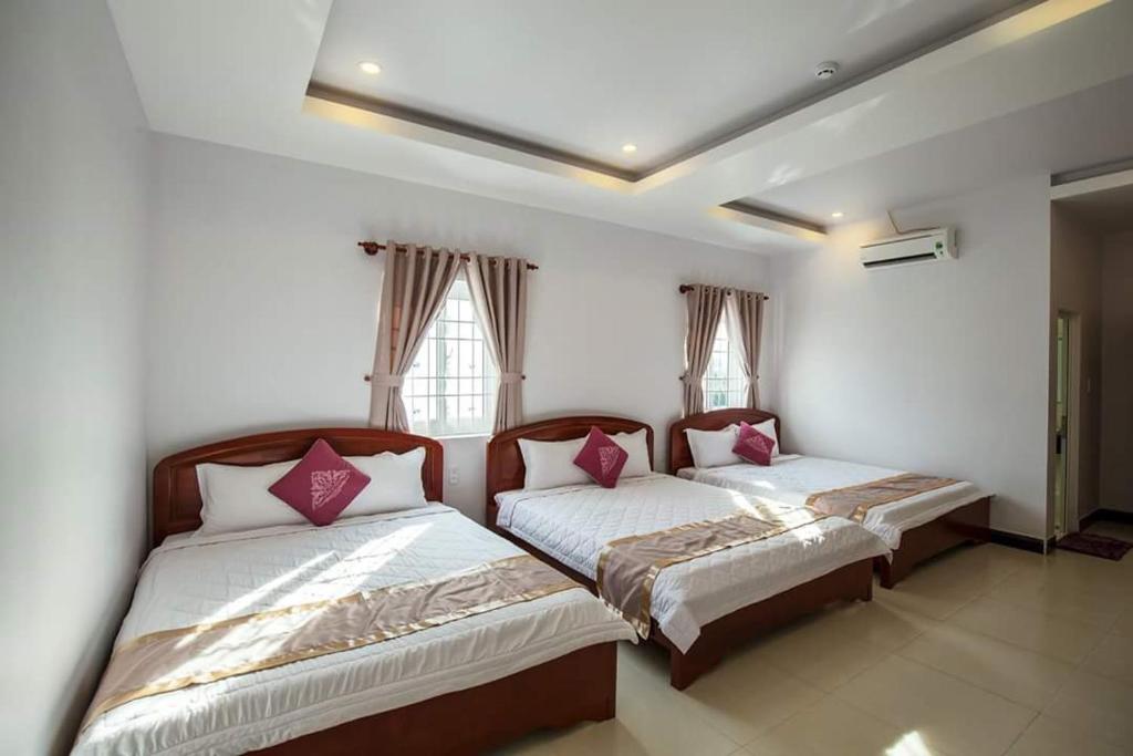 twee bedden in een kamer met twee ramen bij Liên Mỹ Tâm Hotel PQ - by BAY LUXURY in Phu Quoc