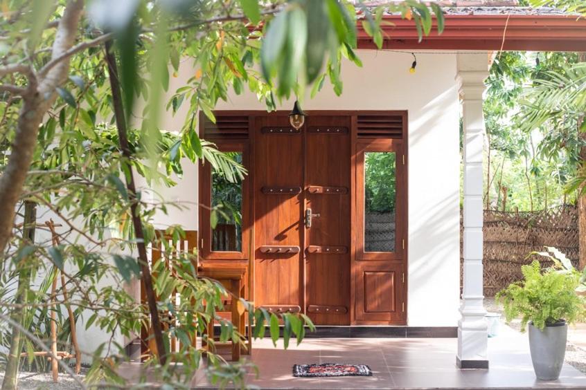 AURORA Midigama في آهانغاما: باب امامي خشبي لبيت به نباتات
