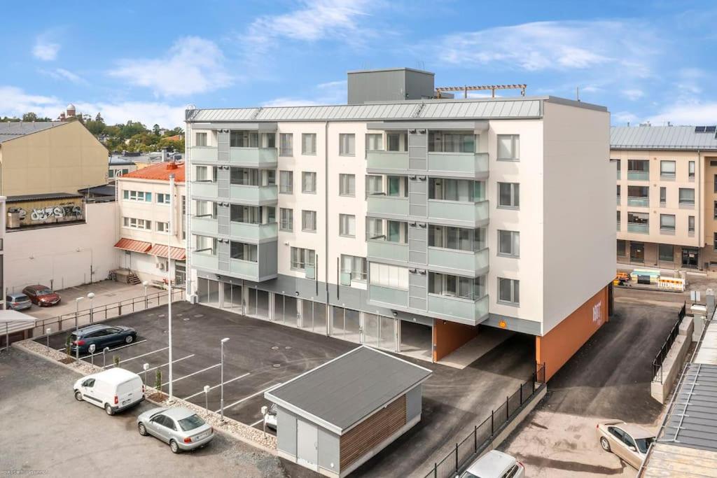 un immeuble d'appartements avec des voitures garées dans un parking dans l'établissement Upea yksiö ydinkeskustasta., à Lappeenranta