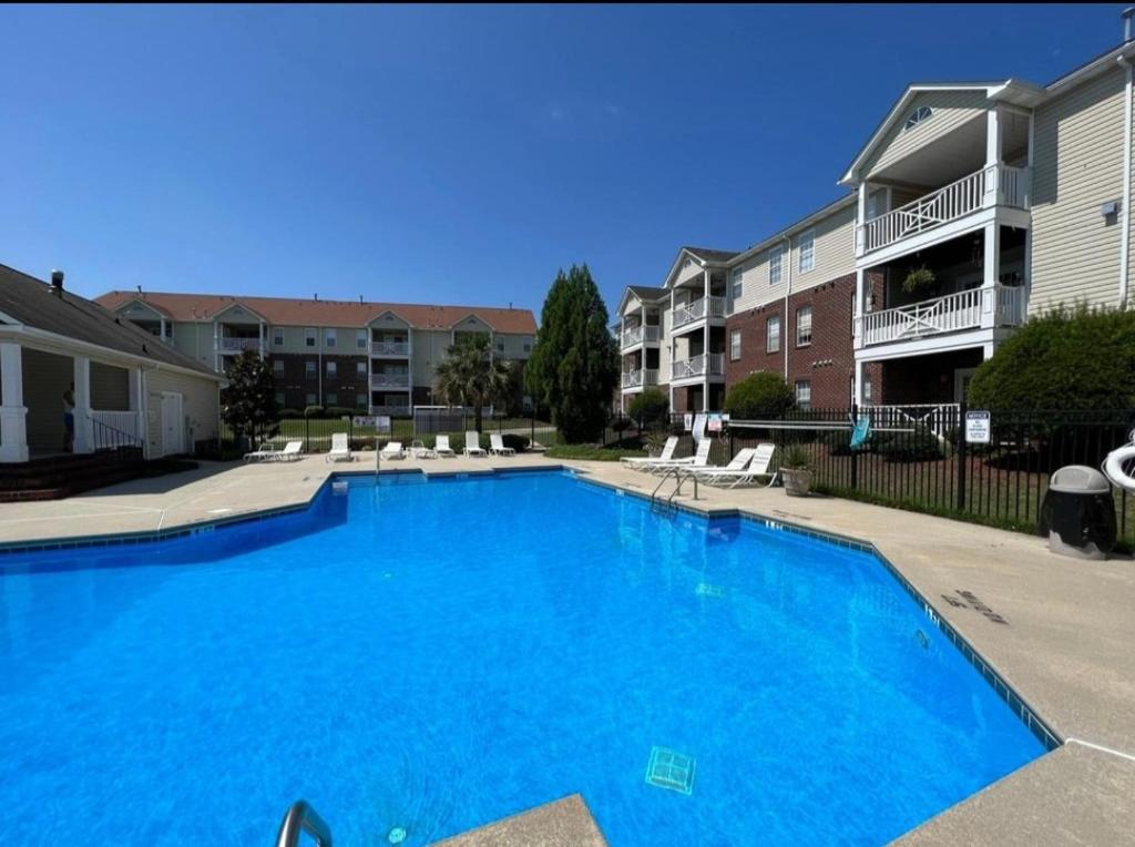 a large blue swimming pool in a apartment complex at Haven Away From Home Ideal For Long Term Stays in Fayetteville